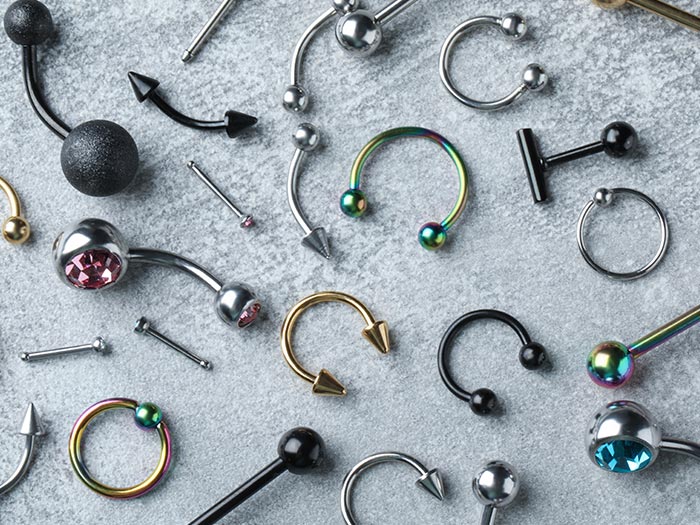 Assorted body jewellery spread out on flat surface